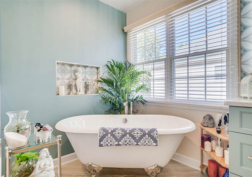 Remodeled restroom with tub and teal painted walls, an example of our Aldie bathroom renovation services.