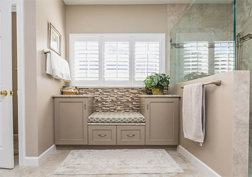 Home restroom with shower and sitting area with cabinets, part of our Aldie bathroom renovation work.