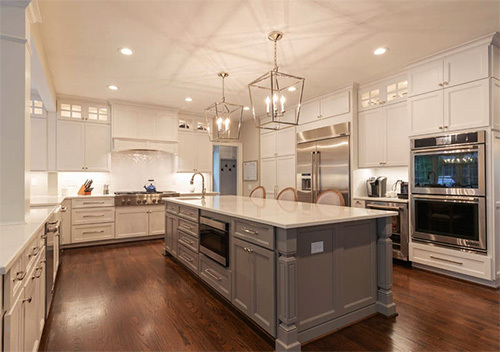 White Alexandria custom kitchen cabinets surrounding a kitchen island.