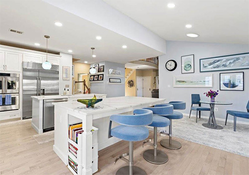 Renovated kitchen with two islands, stools, and new fixtures done for a Burke home remodel.