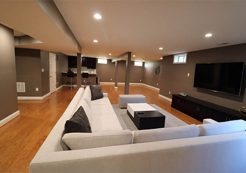 Basement renovation with couches and TV, part of our interior remodeling near Ashburn, Virginia.