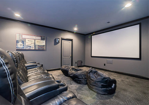 Remodeled basement with leather seats and a projection screen, an example of our Lansdowne on the Potomac, Leesburg interior renovation services.