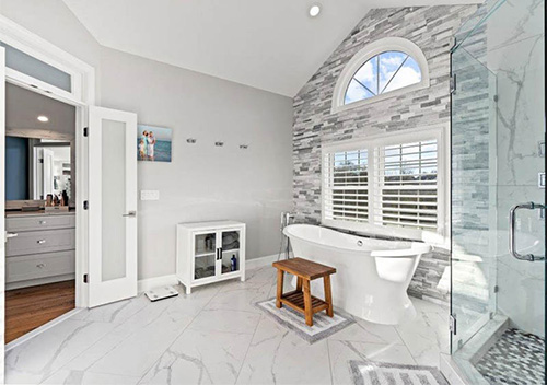 Renovated kitchen with white/grey cabinets and stainless steel appliances set up by our top Annandale remodeler.