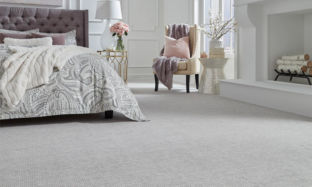 A bedroom with bed, chair, fireplace, and Dunn Loring carpeting.